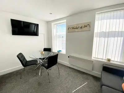 a dining room with a glass table and chairs at Winter Gardens Service Apartments by Blackpool Service Apartments in Blackpool