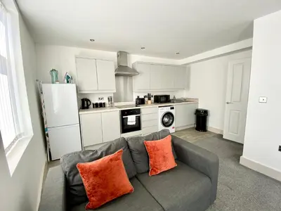 a living room with a couch and a kitchen at Winter Gardens Service Apartments by Blackpool Service Apartments in Blackpool