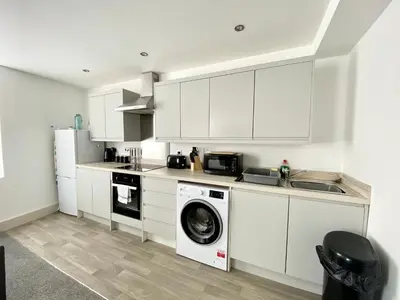 a kitchen with white cabinets and a washing machine at Winter Gardens Service Apartments by Blackpool Service Apartments in Blackpool