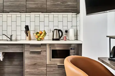 a kitchen with a microwave and a bowl of fruit at Citadines City Centre Liverpool in Liverpool