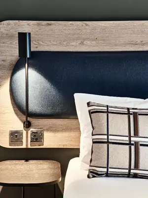 a bedroom with a bed with a wooden headboard at Citadines City Centre Liverpool in Liverpool
