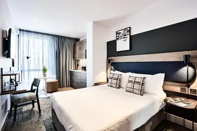 a hotel room with a large bed and a desk at Citadines City Centre Liverpool in Liverpool