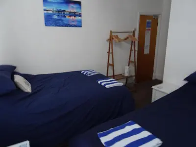a bedroom with two beds and a picture on the wall at Glendowie Hotel in Blackpool
