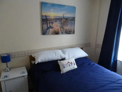 a bedroom with a bed with blue sheets and white pillows at Glendowie Hotel in Blackpool