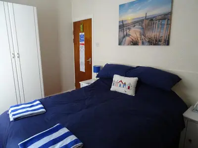 a blue bed with two pillows on top of it at Glendowie Hotel in Blackpool