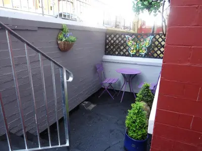 a patio with two chairs and a table and a railing at Glendowie Hotel in Blackpool
