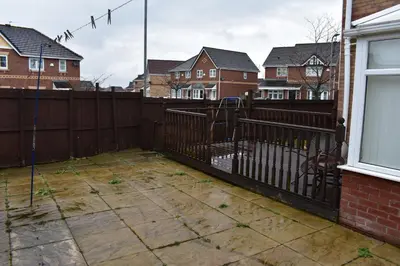 a backyard with a fence and some houses at Redwood House in Liverpool