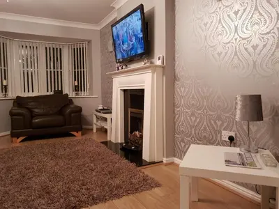 a living room with a television above a fireplace at Redwood House in Liverpool