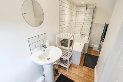 a bathroom with a sink and a mirror at Sapphire Home Stay in Liverpool