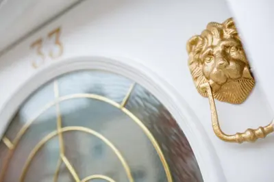 a clock with a gold lion head on a wall at Sapphire Home Stay in Liverpool