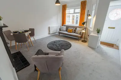 a living room with a couch and a table and chairs at Sapphire Home Stay in Liverpool