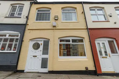 a yellow house with white doors and windows at Sapphire Home Stay in Liverpool