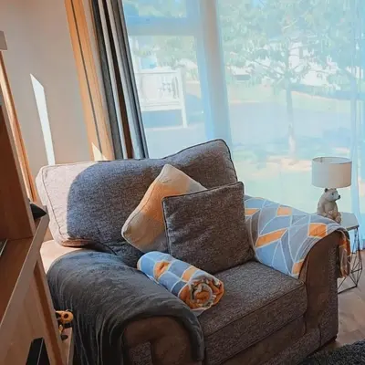 a living room with a couch and a lamp at Rydal 38 Haven lakeland LA11 7LT in Flookburgh