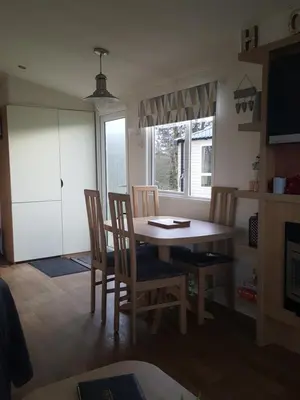 a kitchen with a dining room table and chairs at Rydal 38 Haven lakeland LA11 7LT in Flookburgh
