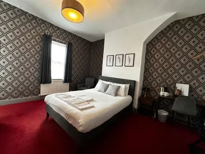 a bedroom with a large bed and a window at The Derby Hotel in Barrow in Furness