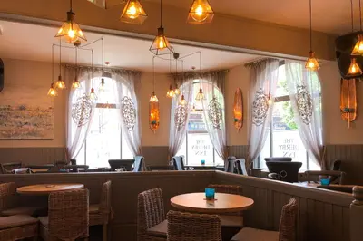 a restaurant with tables and chairs and windows at The Derby Hotel in Barrow in Furness