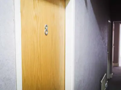a wooden door with a handle in a room at The Derby Hotel in Barrow in Furness