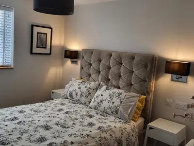 a bedroom with a bed with a large headboard at Yew Fold in Soutergate