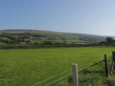 a fence in the middle of a green field at Yew Fold in Soutergate