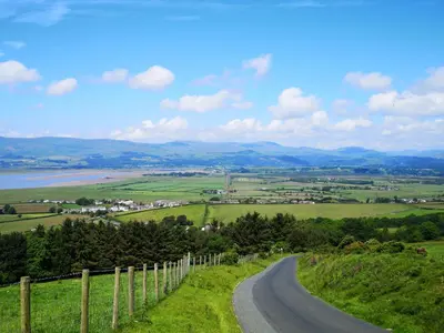 a winding road on a hill with a fence at Yew Fold in Soutergate
