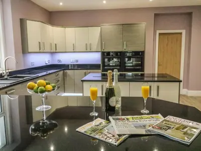 a kitchen with a counter with two glasses of orange juice at Ellie's Lodge in Ulverston
