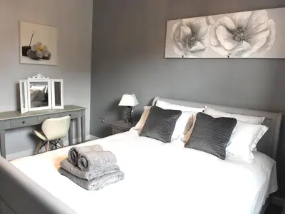 a bedroom with a large white bed with two pillows at Ellie's Lodge in Ulverston