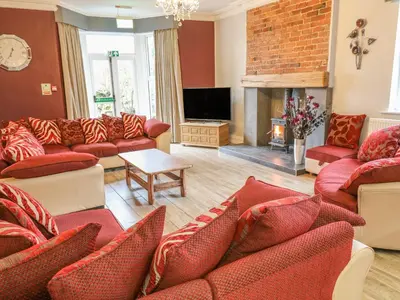 a living room with red couches and a fireplace at Ellie's Lodge in Ulverston