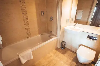 a bathroom with a sink and a tub and a toilet at Blackpool Football Club Stadium Hotel, a member of Radisson Individuals in Blackpool