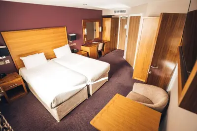 a hotel room with a bed and a chair at Blackpool Football Club Stadium Hotel, a member of Radisson Individuals in Blackpool