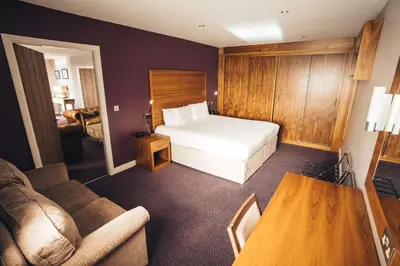 a hotel room with a bed and a couch at Blackpool Football Club Stadium Hotel, a member of Radisson Individuals in Blackpool