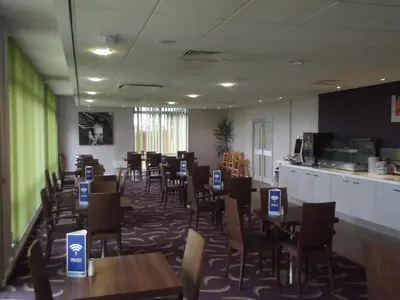 a restaurant with tables and chairs in a room at Holiday Inn Express Preston South by IHG in Preston