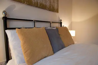 a bedroom with a bed with two pillows on it at Bolton Executive Apartment in Bolton