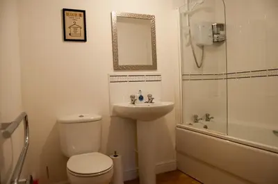 a bathroom with a toilet and a sink and a shower at Bolton Executive Apartment in Bolton