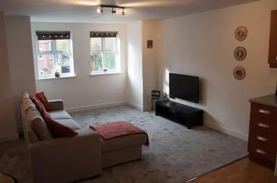 a living room with a couch and a tv at Bolton Executive Apartment in Bolton