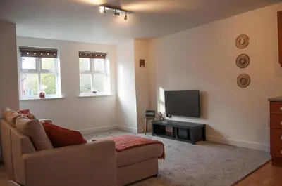 a living room with a couch and a flat screen tv at Bolton Executive Apartment in Bolton
