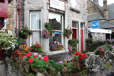 a bunch of flowers in pots outside of a building at Somerset House B&B in Grange Over Sands
