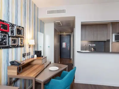 a kitchen with a desk and blue chairs in a room at Aparthotel Adagio Liverpool City Centre in Liverpool