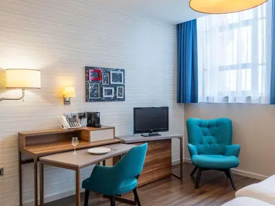 a room with a desk and two chairs and a television at Aparthotel Adagio Liverpool City Centre in Liverpool