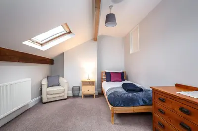 a bedroom with a bed and a chair and a skylight at Bedzzz - Booklovers Dream in Preston