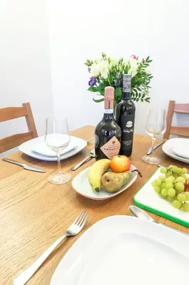 a table with a plate of fruit and wine bottles at Bedzzz - Booklovers Dream in Preston