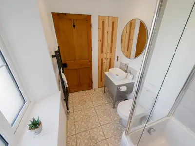 a bathroom with a toilet and a mirror at Dunmail House in Grange Over Sands