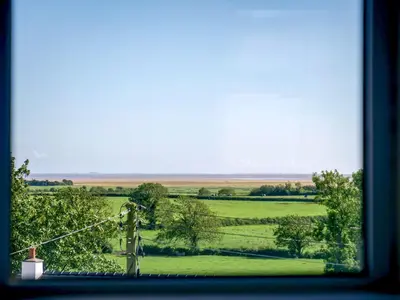 a view of a green field from a window at Dunmail House in Grange Over Sands