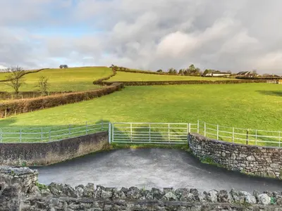 a large grassy field with a gate in a field at Dunmail House in Grange Over Sands
