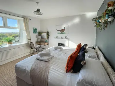 a bedroom with a large white bed with pillows on it at Dunmail House in Grange Over Sands