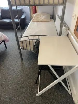 a room with two bunk beds and a table at Backpackers Blackpool Hotel & Suites in Blackpool