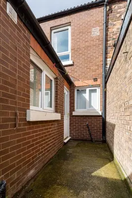 a brick building with a door and two windows at Comfortable Liverpool Townhouse - Close to City & Stadium in Liverpool