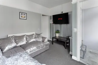 a living room with a couch and a flat screen tv at Comfortable Liverpool Townhouse - Close to City & Stadium in Liverpool