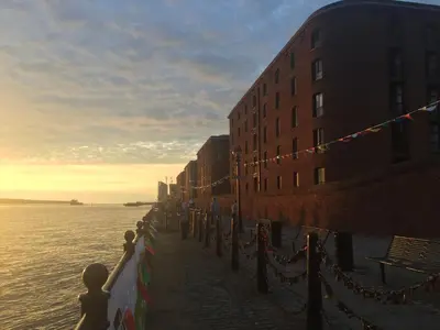 a group of people standing on a sidewalk next to the water at Beautiful Loft City Centre, Liverpool 1 in Liverpool