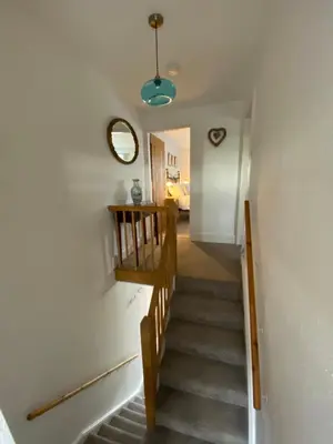 a stairway leading up to a hallway with a mirror at The Stopping Point- Exceptional Cumbrian Cottage in Flookburgh