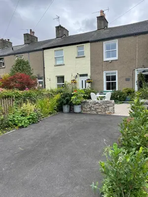 a house with a driveway in front of it at The Stopping Point- Exceptional Cumbrian Cottage in Flookburgh